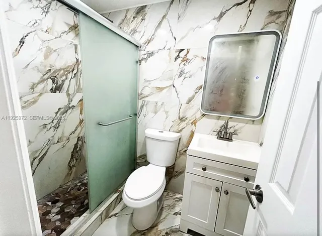 a bathroom with a sink toilet and shower