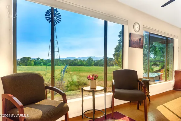 a view of a workspace with furniture and a floor to ceiling window
