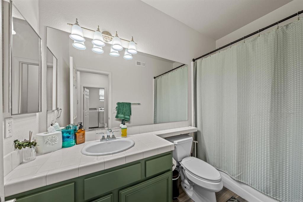 2007 Pleasant Waters Court Spring Valley, CA 91977 - Photo 18 of 22 a bathroom with a sink a toilet a mirror and shower curtain