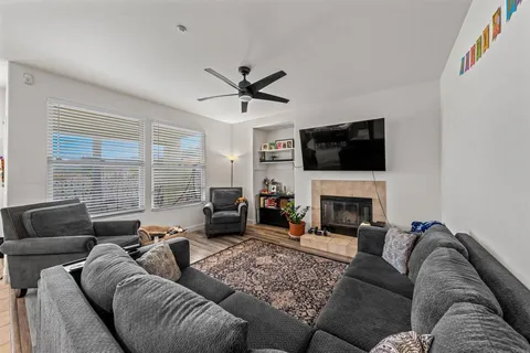 a living room with furniture a fireplace and a flat screen tv