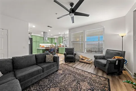 a living room with furniture ceiling fan and a window
