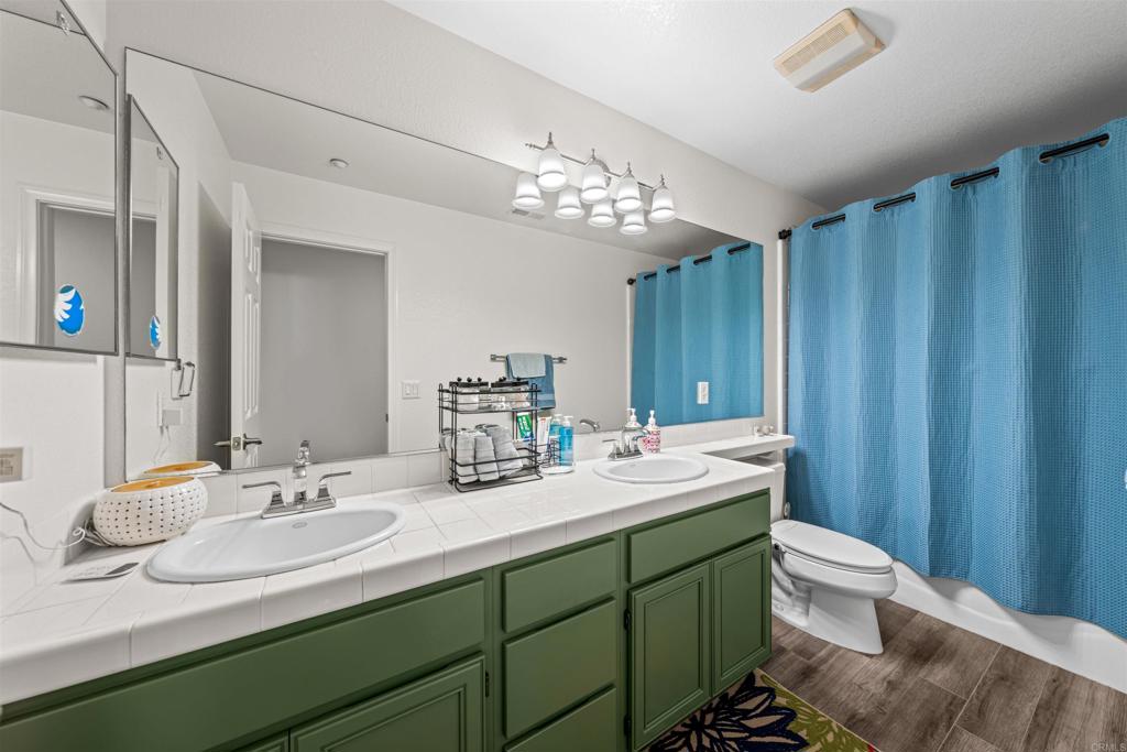 2007 Pleasant Waters Court Spring Valley, CA 91977 - Photo 10 of 22 a bathroom with double vanity sink a toilet and a mirror