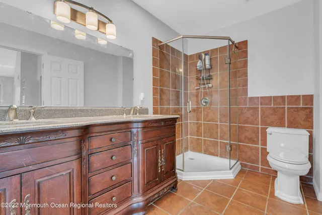 a bathroom with a granite countertop sink a toilet and a mirror