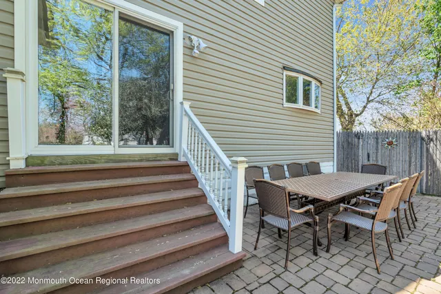 a view of a patio with table and chairs with wooden floor and fence