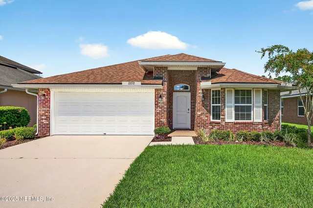 a kitchen with granite countertop a refrigerator a sink dishwasher a stove and white cabinets with wooden floor