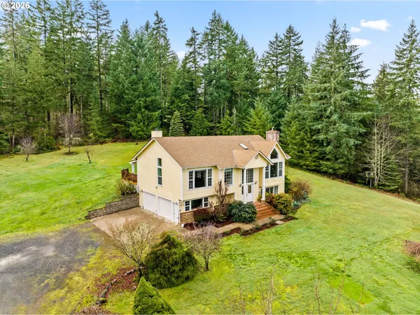 a view of a house with a big yard plants and large trees