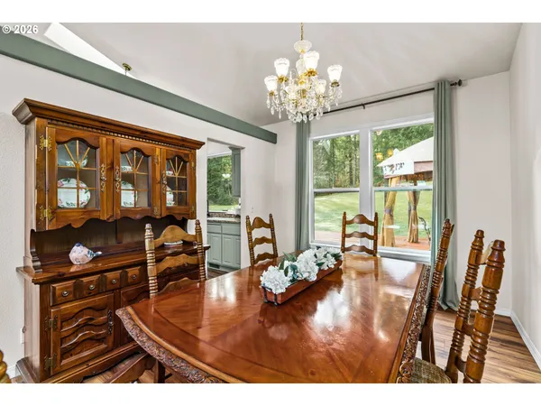 a view of a dining room with furniture a chandelier and wooden floor