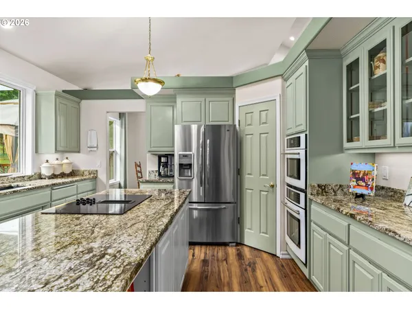 a kitchen with kitchen island granite countertop a refrigerator oven stove a sink and dishwasher