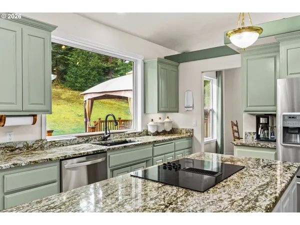 a kitchen with stainless steel appliances granite countertop sink stove and granite counter top