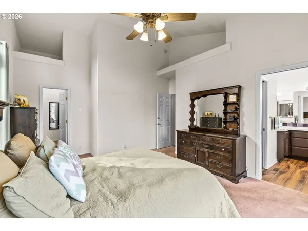 a bedroom with a bed and a dresser with mirror