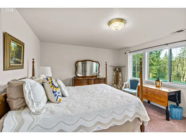 a bedroom with a bed and a large window