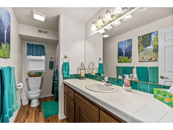 a bathroom with a sink a toilet a mirror and shower