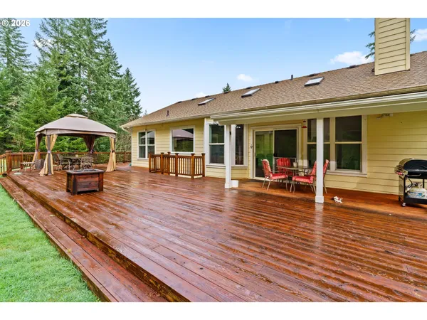 a view of a house with wooden deck and furniture