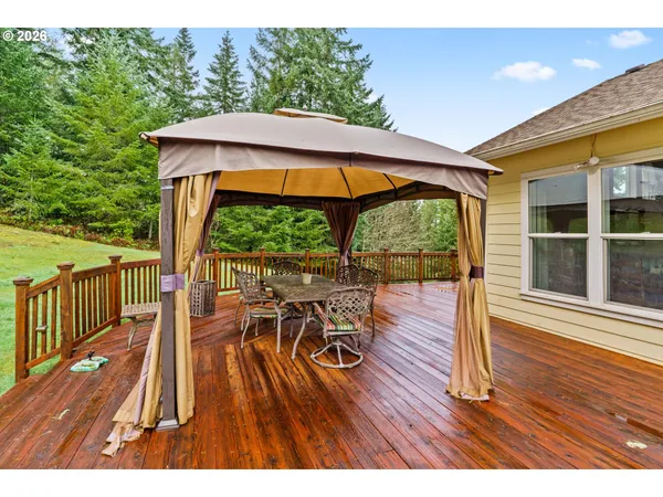 a view of a patio with table and chairs under an umbrella with wooden floor