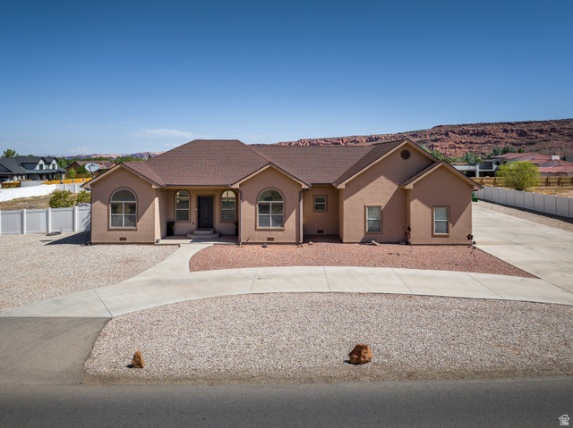 4635 East Sunny Acres Lane Moab, UT 84532 - Photo 2 of 56 Sizable stucco residence featuring a brown shingled roof and a desert rock landscape
