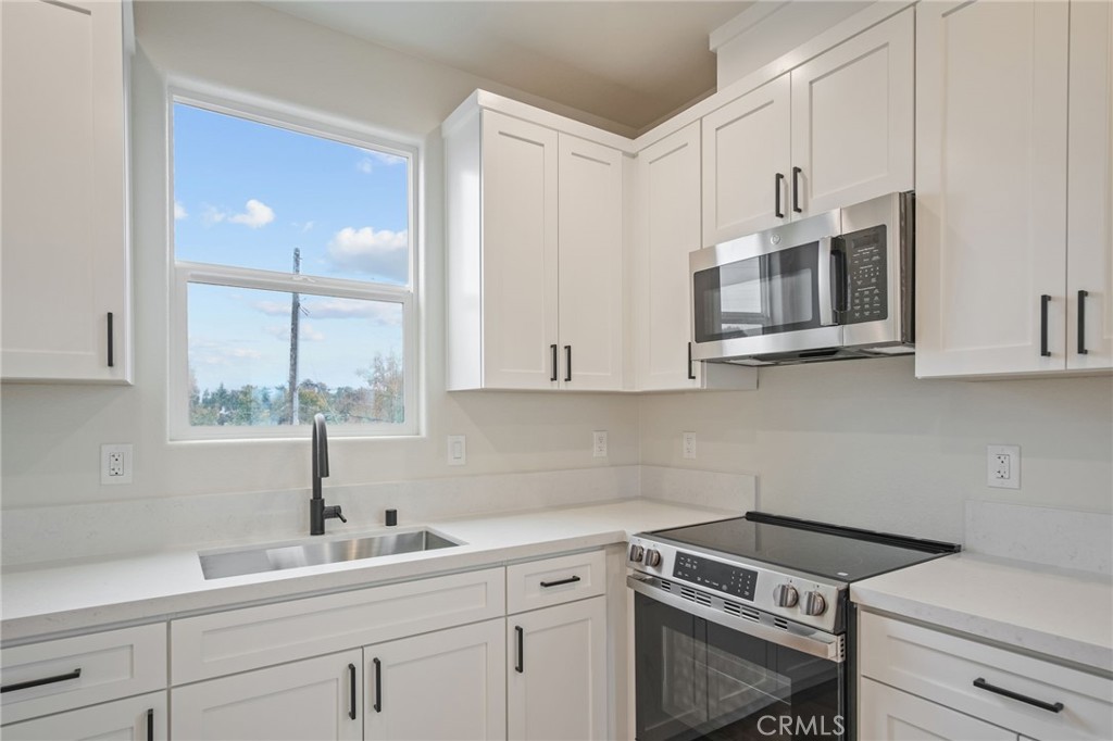 243 West 3rd Street Tracy, CA 95376 - Photo 14 of 29 a kitchen with appliances a sink and cabinets