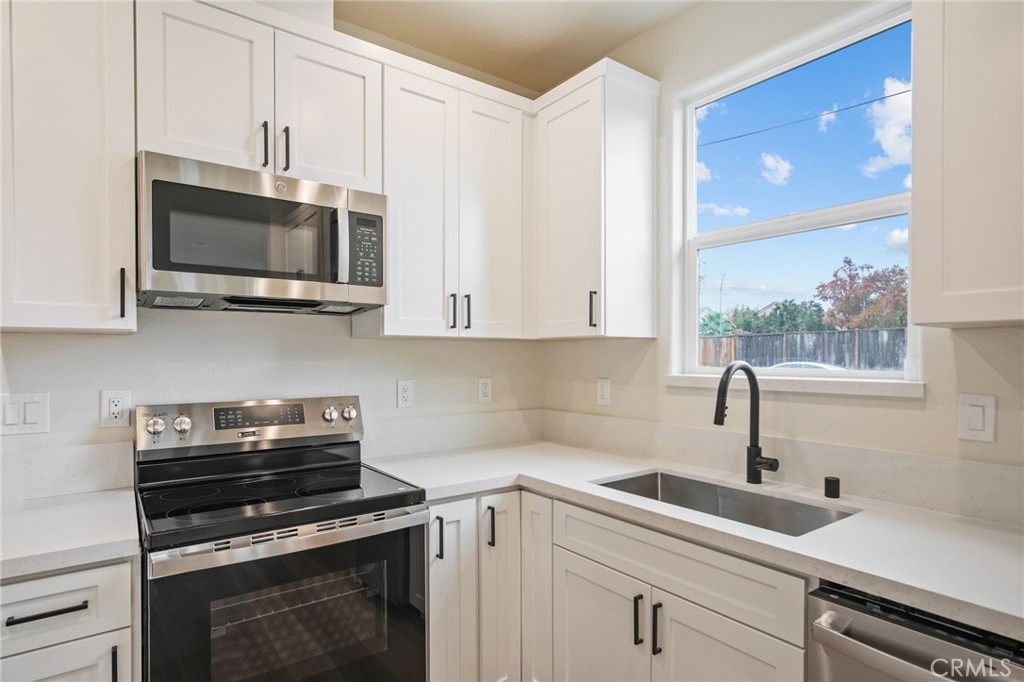 243 West 3rd Street Tracy, CA 95376 - Photo 26 of 29 a kitchen with stainless steel appliances a stove a sink and a microwave