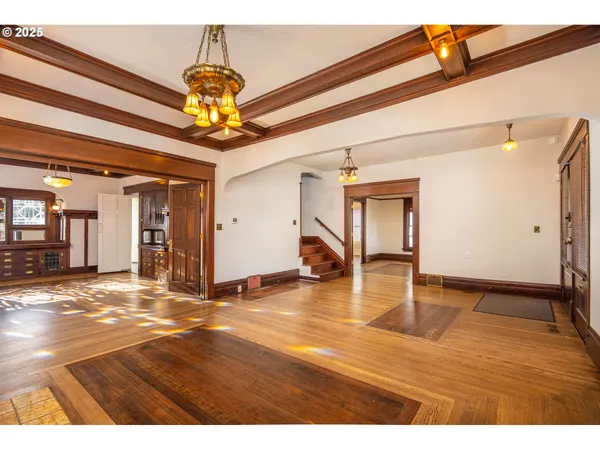 a view of an empty room and window with wooden floor