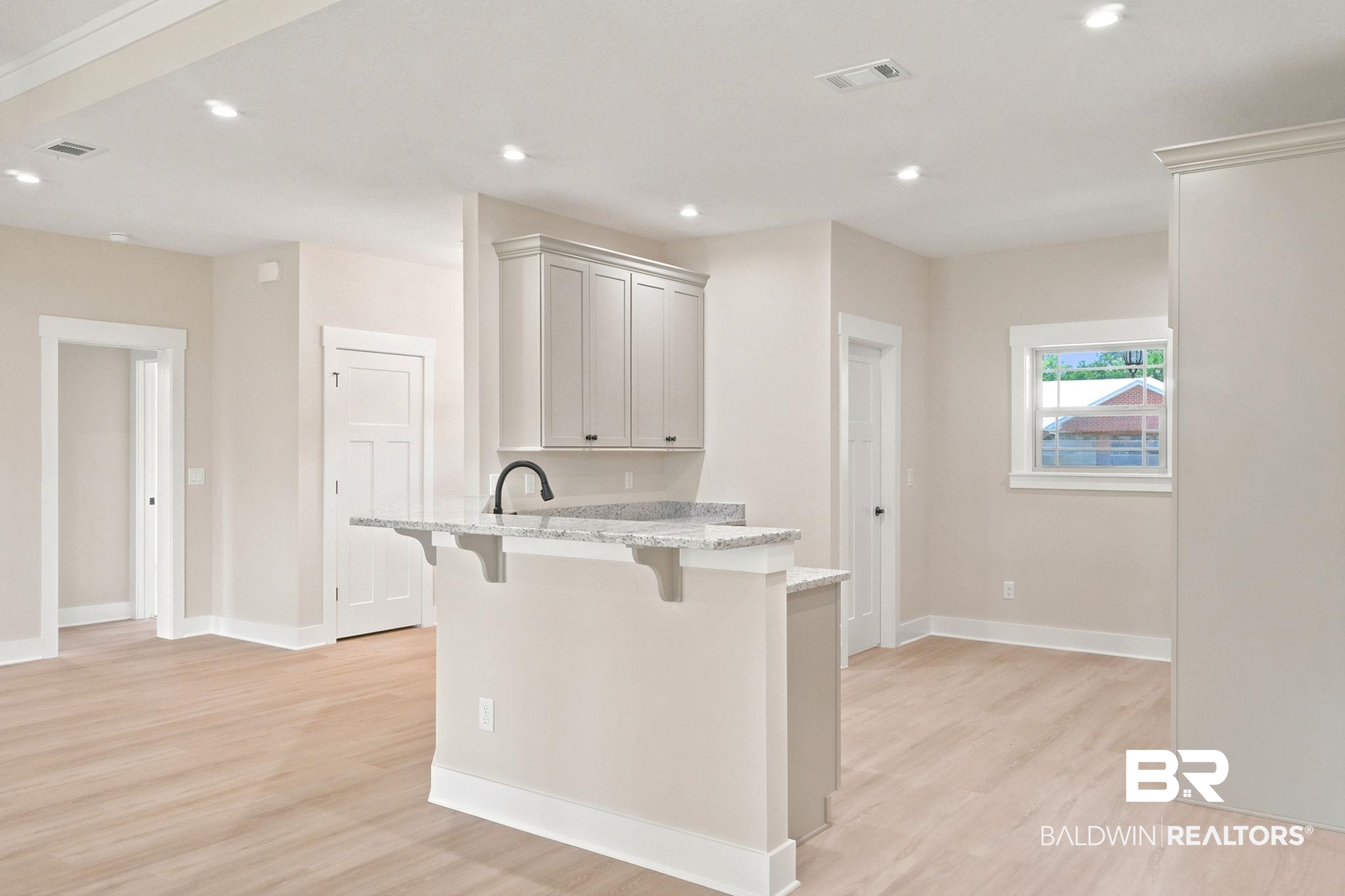 32656 Arbor Ridge Circle Lillian, AL 36549 - Photo 9 of 56 Kitchen island featuring granite-style countertop, integrated sink, and matte black faucet