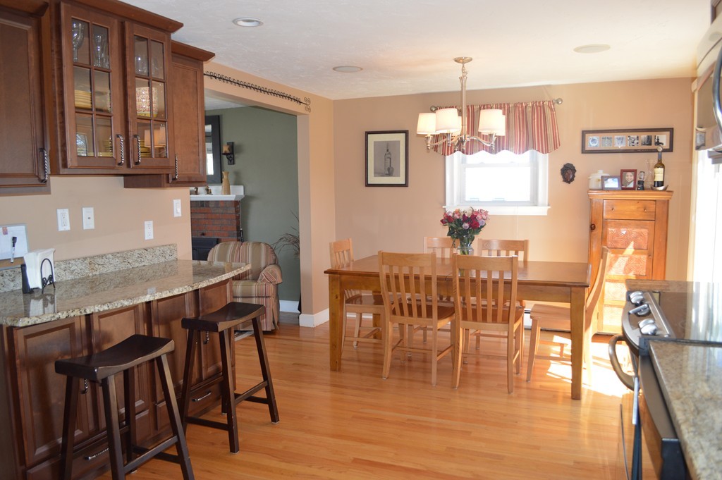 39 Miriam Road Waltham, MA 02451 - Photo 3 of 20 a dining room with wooden floor a chandelier a glass table and chairs