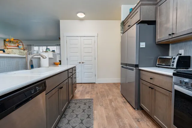 a kitchen with stainless steel appliances a sink stove and refrigerator