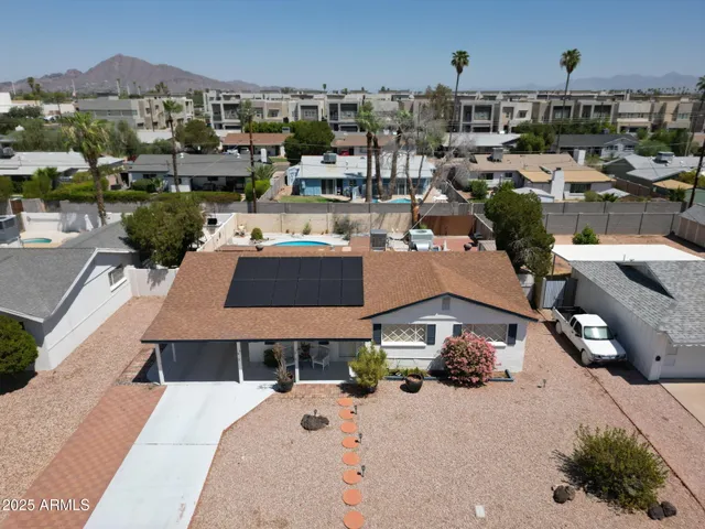 an aerial view of residential houses with outdoor space and parking