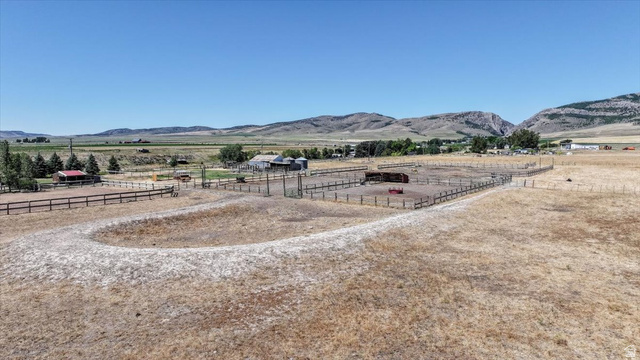 1634 West Arimo Road Arimo, ID 83214 - Photo 71 of 89 Expansive property featuring a large fenced paddock, additional fenced enclosures, multiple outbuildings, and distant mountainous terrain