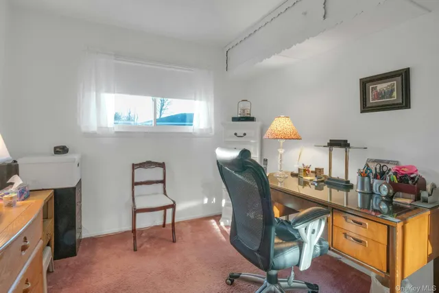 a view of a workspace with furniture and a window