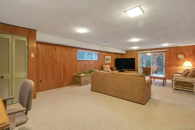 a living room with furniture a flat screen tv and a large window