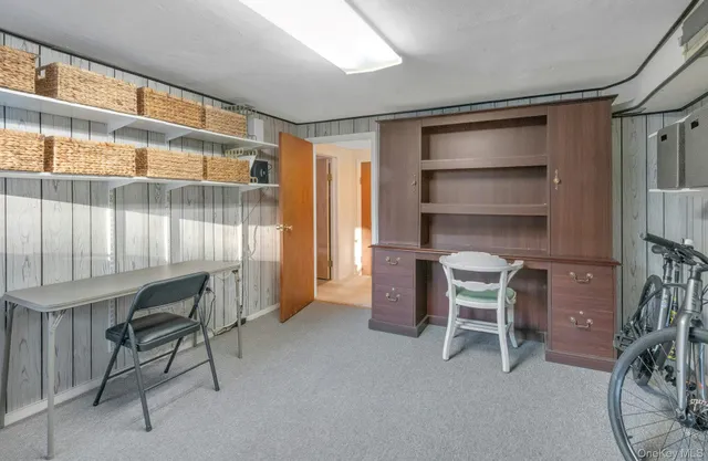 a view of a workspace with furniture and a window