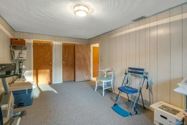 a spacious bedroom with a bed and a chair