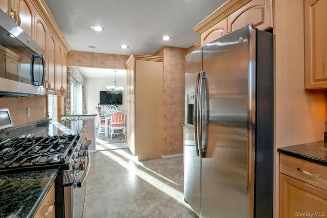 a kitchen with stainless steel appliances granite countertop a refrigerator and a stove
