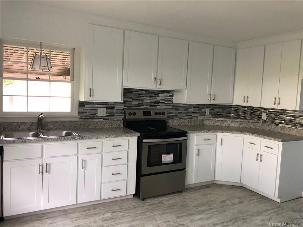 141 South Hillside Street Rutherfordton, NC 28139 - Photo 3 of 7 a kitchen with granite countertop white cabinets and stainless steel appliances