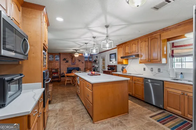 a large kitchen with a table chairs refrigerator and a sink