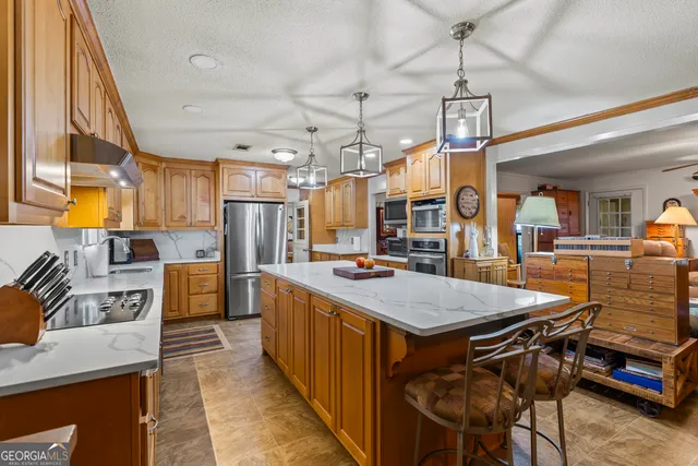 a dining hall with stainless steel appliances granite countertop a stove and a dining table view