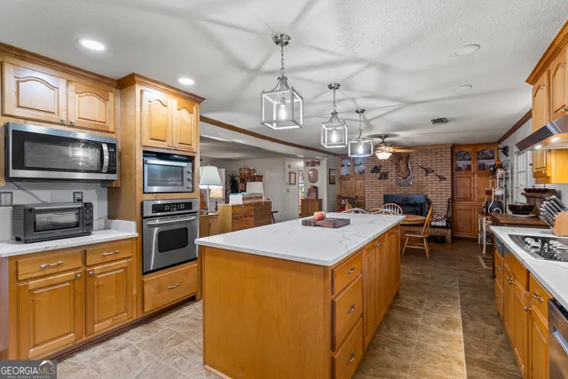 a dining room with stainless steel appliances lots of furniture and a chandelier