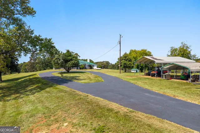 a view of a house with backyard and sitting area