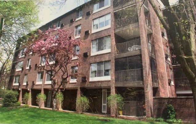 a front view of a multi story building with yard