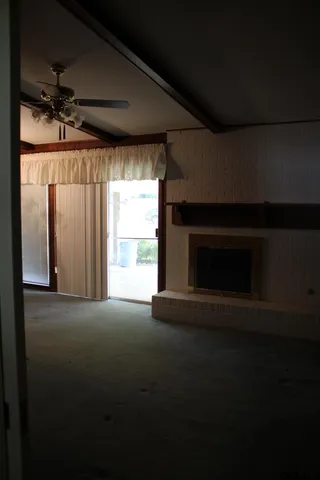 a view of empty room with wooden floor and fireplace