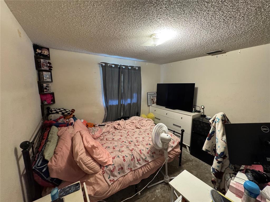 1004 Melrose Street Seffner, FL 33584 - Photo 14 of 40 a bedroom with a bed and a flat screen tv