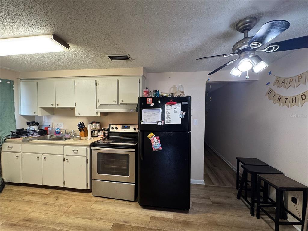1004 Melrose Street Seffner, FL 33584 - Photo 19 of 40 a kitchen with stainless steel appliances granite countertop a stove cabinets and wooden floor