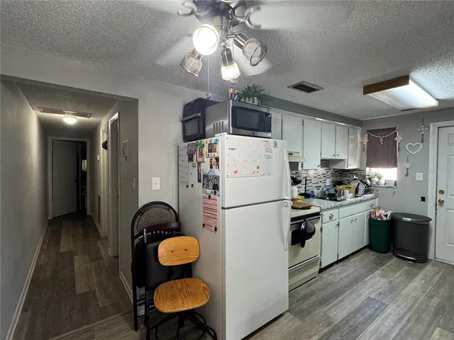 a kitchen with stainless steel appliances a stove a sink dishwasher and a refrigerator with wooden floor