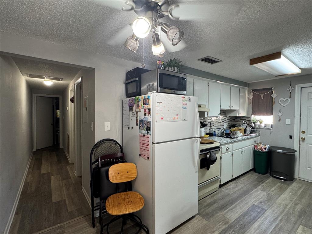 1004 Melrose Street Seffner, FL 33584 - Photo 24 of 40 a kitchen with stainless steel appliances a refrigerator a sink dishwasher a dining table and chairs with wooden floor