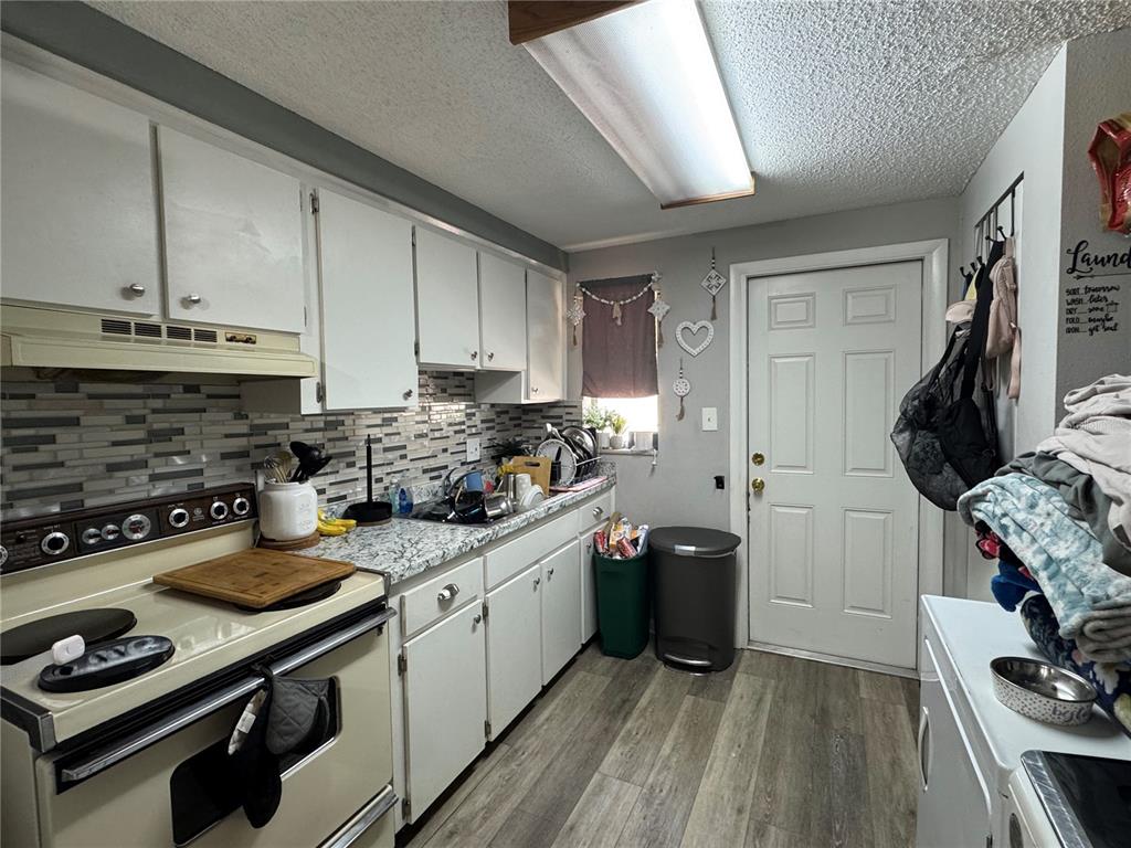 1004 Melrose Street Seffner, FL 33584 - Photo 26 of 40 a kitchen with stainless steel appliances a stove a sink dishwasher and a refrigerator with wooden floor