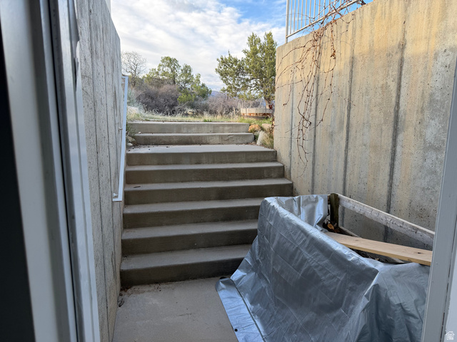 10000 North 6730th East Spring City, UT 84662 - Photo 18 of 31 Concrete retaining walls with integrated concrete staircase and white metal handrail