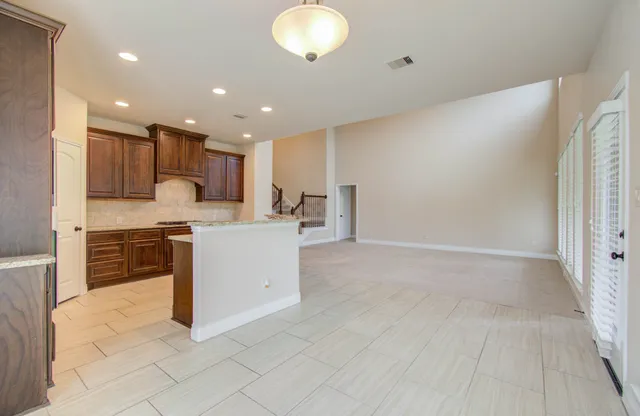 a kitchen with stainless steel appliances granite countertop a stove a sink and a refrigerator