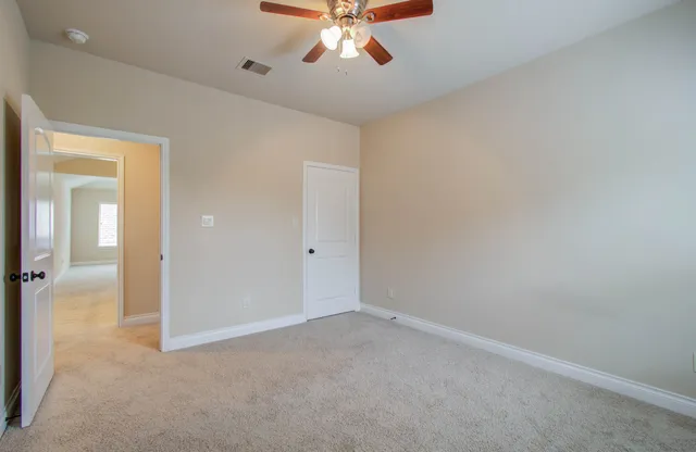 an empty room with a ceiling fan and a window