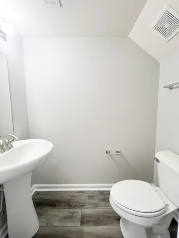 a bathroom with a sink a toilet and a mirror