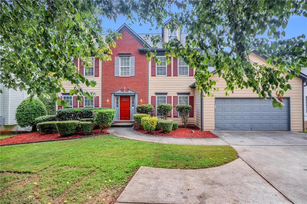 a view of a house with a yard and tree s