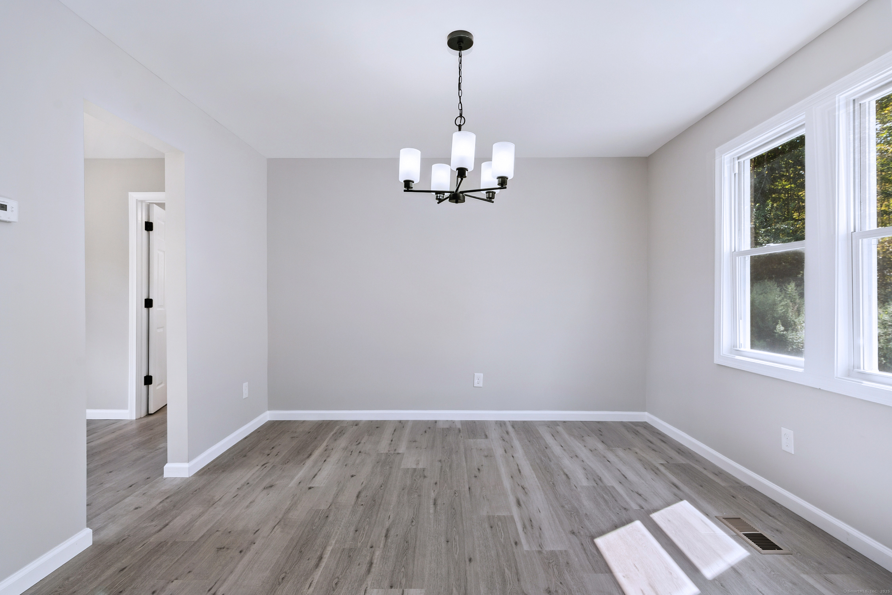 260 Hayden Hill Road Torrington, CT 06790 - Photo 11 of 18 a view of a room with wooden floor a ceiling fan and windows